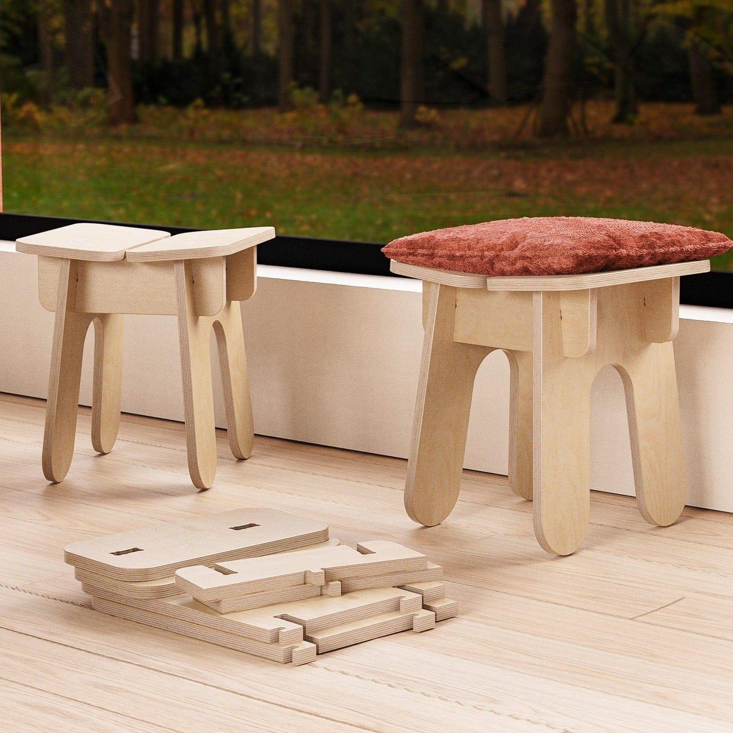 Two BURIJ wood stools beside a large window, one topped with a rust cushion and unassembled stool components arranged on the floor