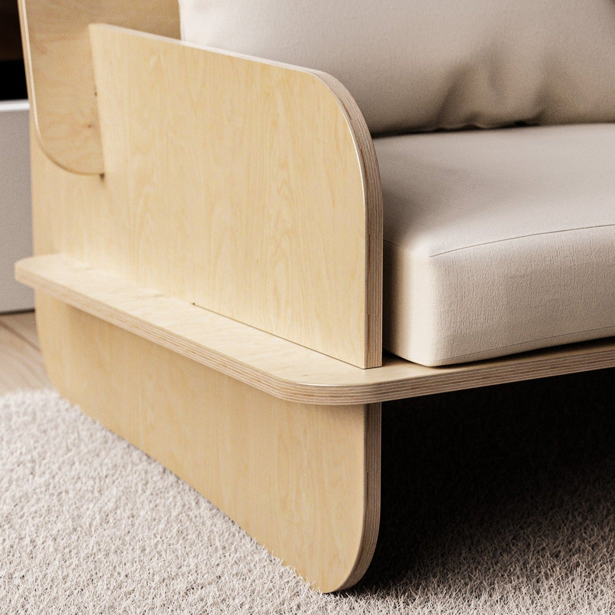 Close-up of the Franklin Low Seater showing its curved plywood side panel, layered wood edges and white upholstered cushions