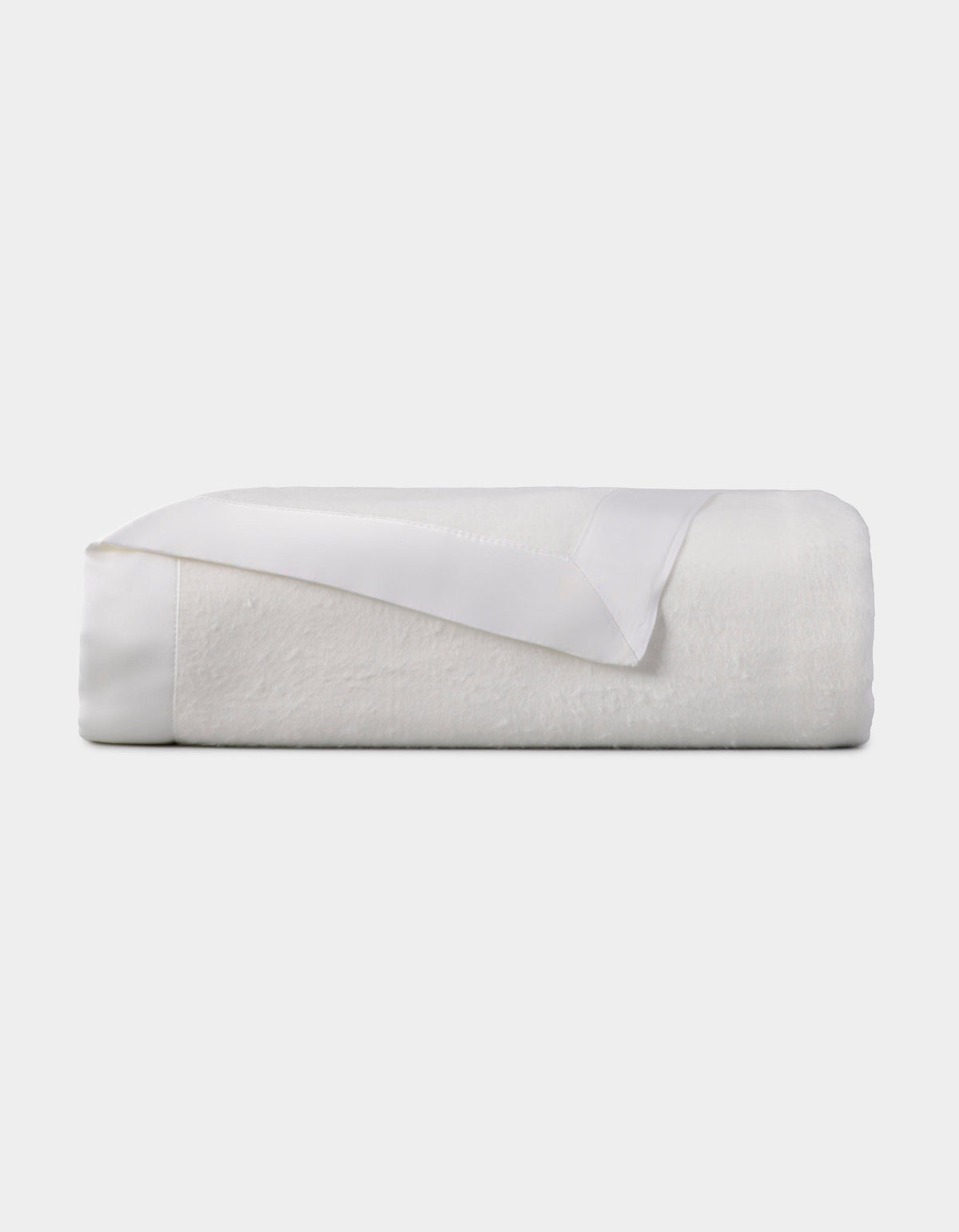 White blanket folded into a compact rectangular stack, with one corner turned back to reveal the matching satin border.