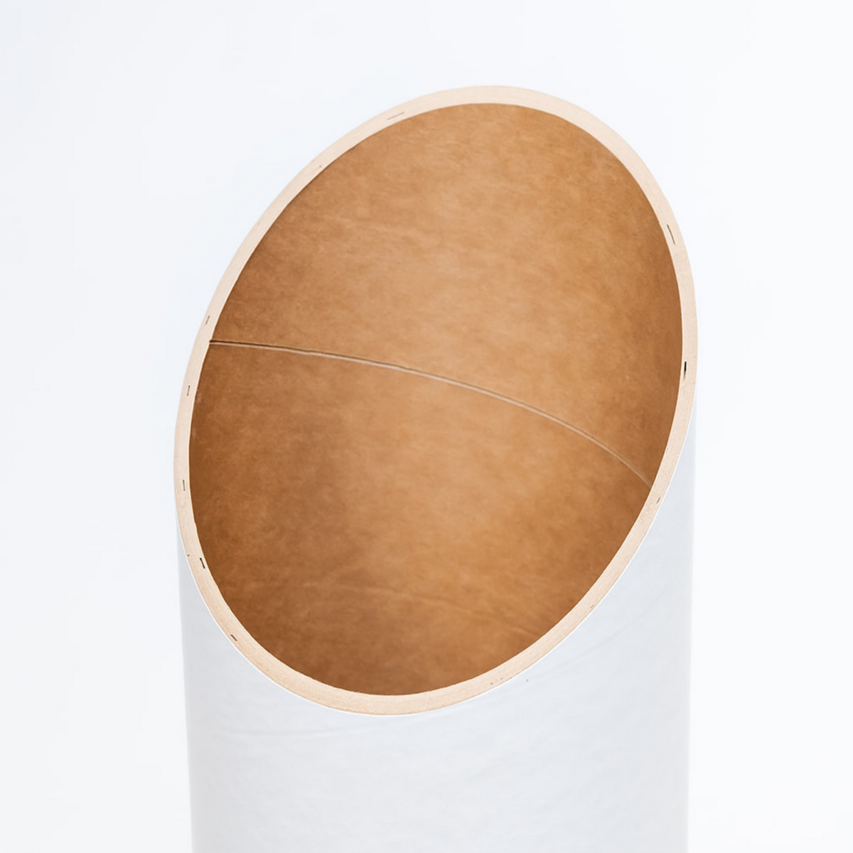 Close-up looking into the tube’s wide angled opening, revealing the smooth brown recycled-paper lining.