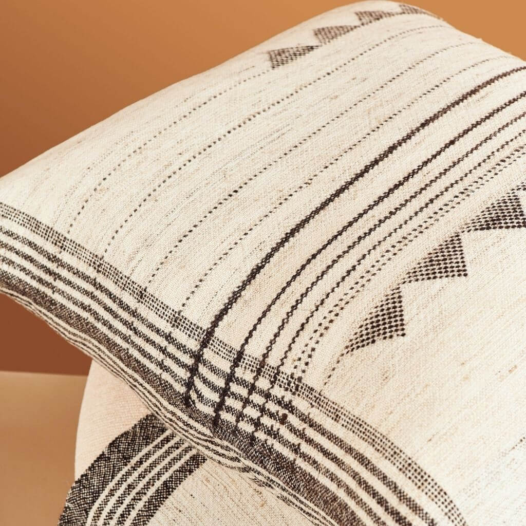 Close-up of the handwoven ivory fabric, black stripes, and geometric triangle detailing.