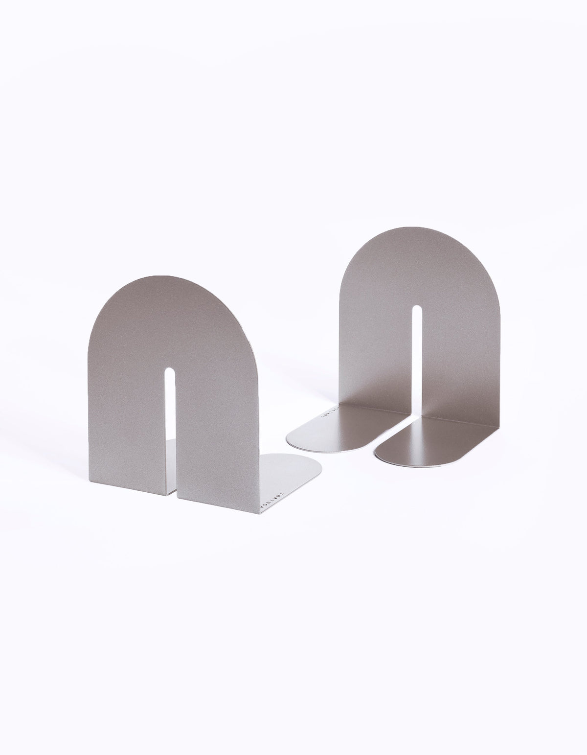 Pale taupe Tortuga Forma Dumbo Bookend Pairs - The Architect Collection on white, with one facing forward and the other angled to reveal its folded base and slim profile.