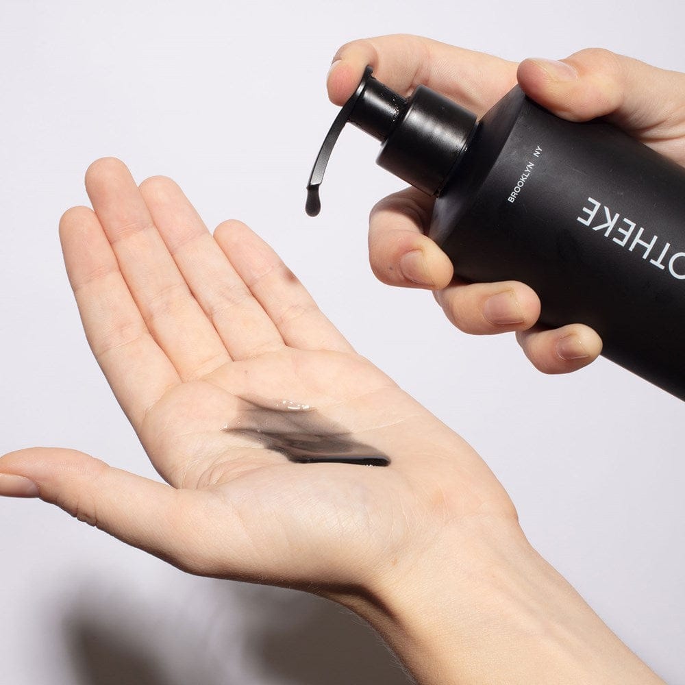 APOTHEKE Charcoal Liquid Soap dispensed onto a palm, showing its black color and texture
