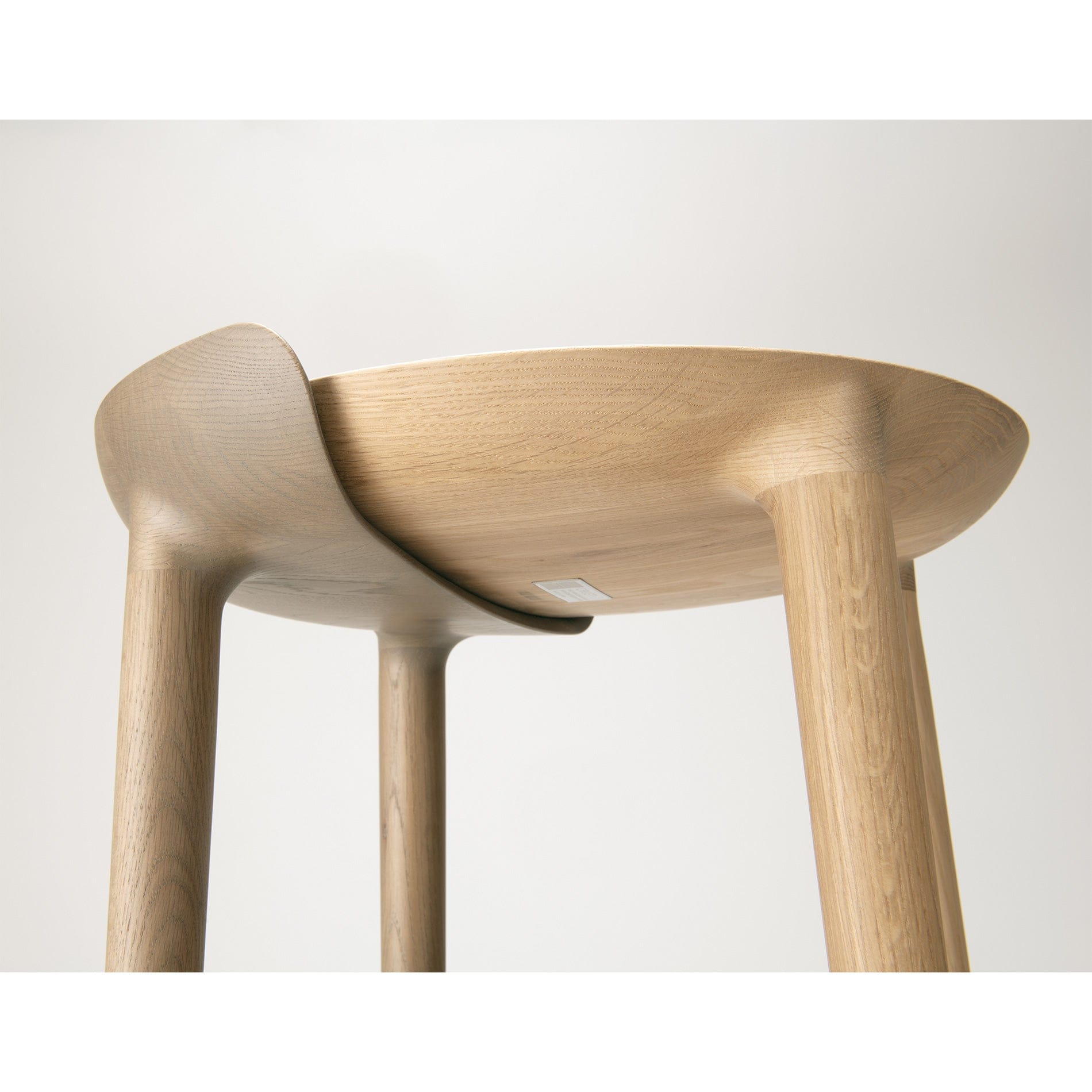 Close-up of CRUST Bar Stool leg and sculpted seat form — refined natural wood furniture available at Japandi Supply House.
