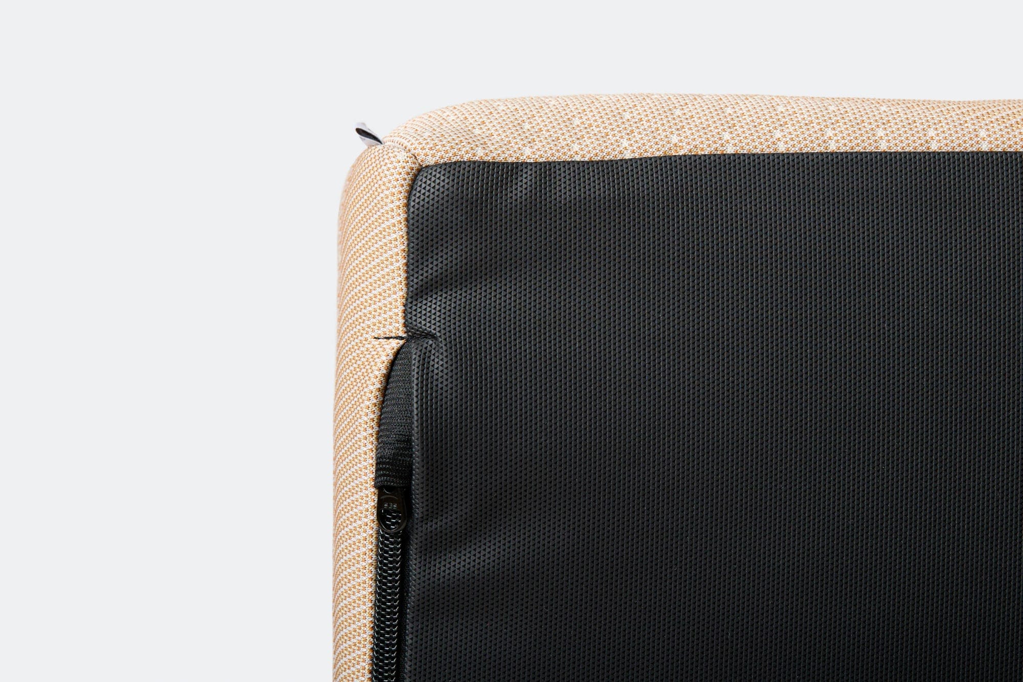 Close-up of a beige fabric surface with a black zipper on a light gray background