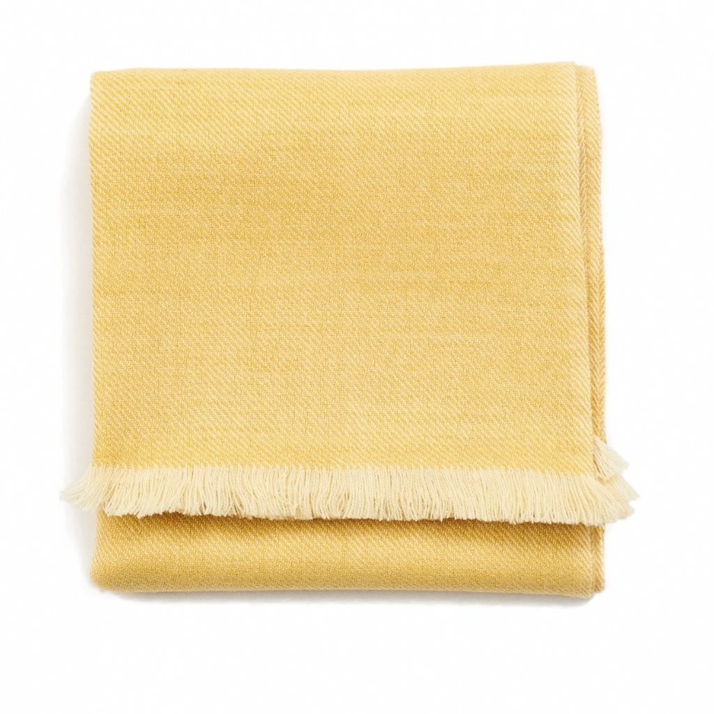 Folded soft yellow color variation of the Variously Plush Soft Twill Merino Throw with matching fringe