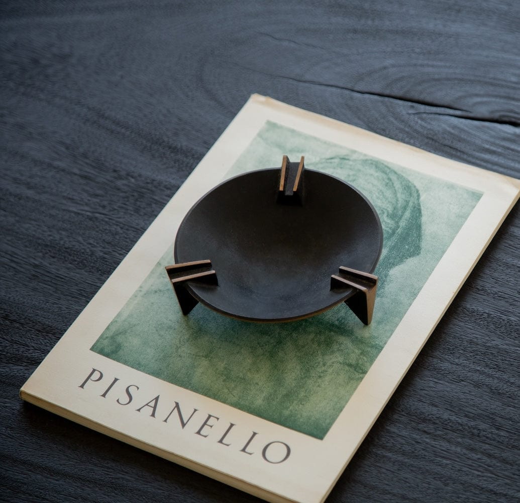 Decorative Milan ashtray with brass details on art book
