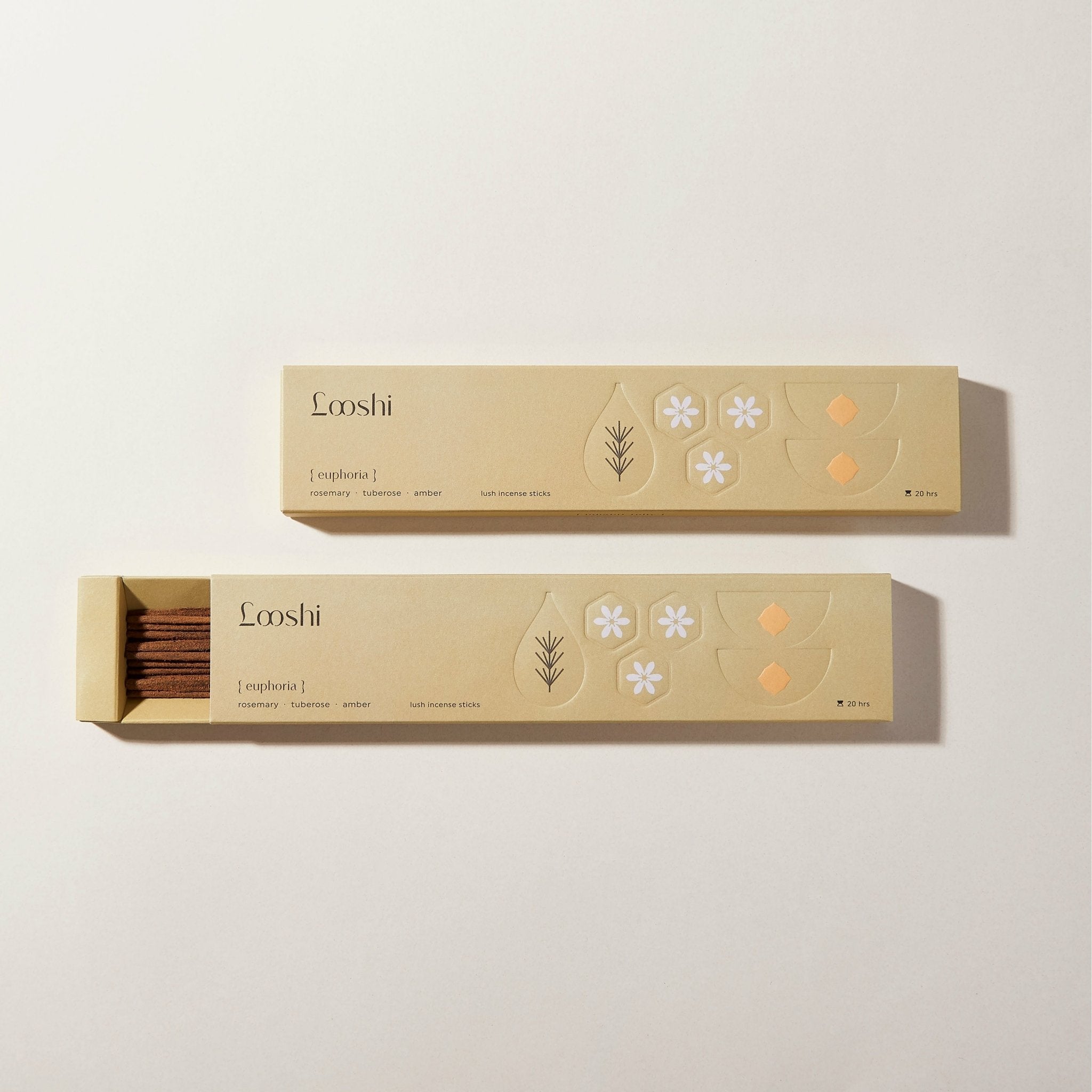 Open and closed golden yellow boxes of Looshi Euphoria incense sticks with floral and botanical designs on a cream background