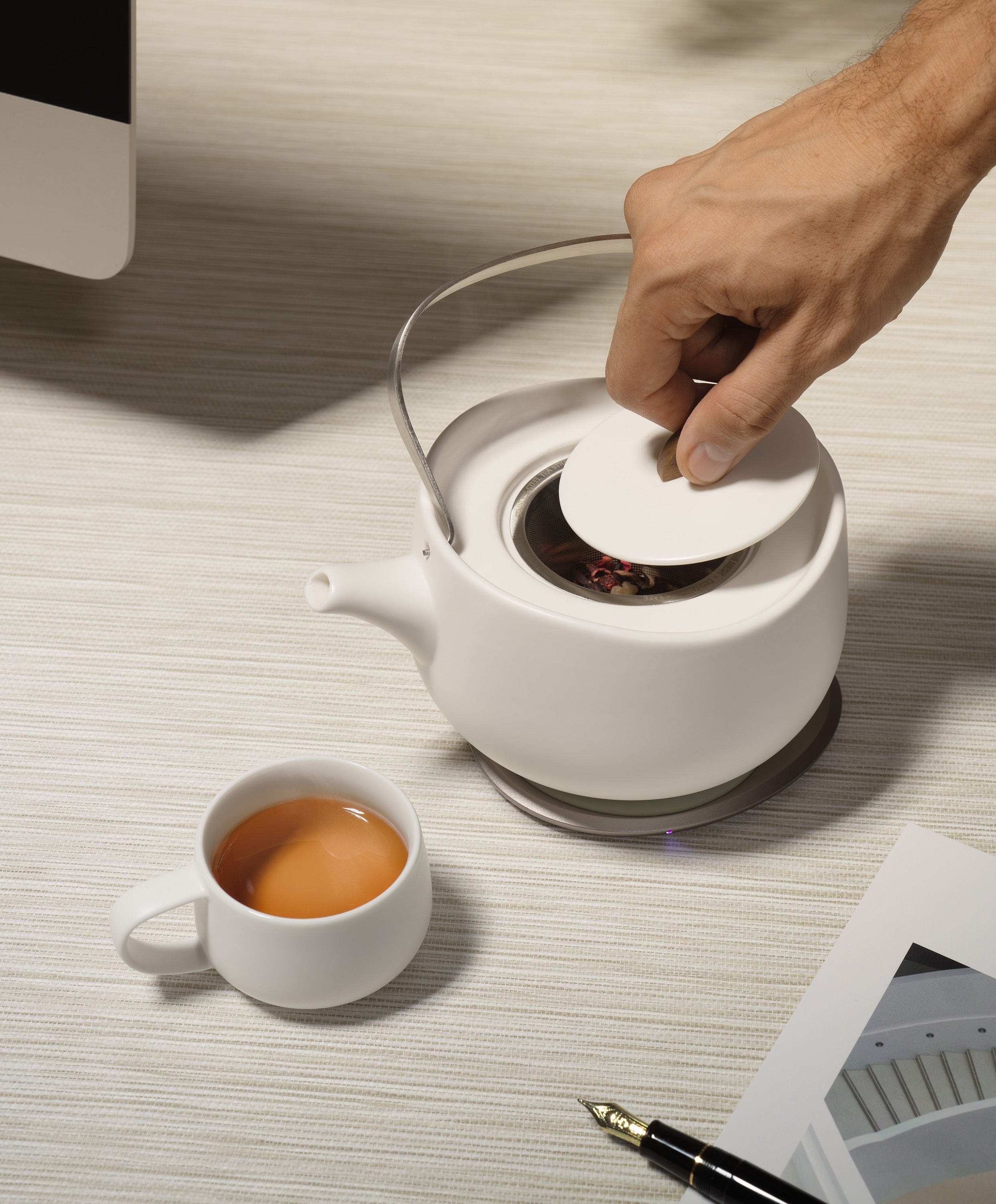 Leiph Self-heating Teapot Bundle Set in use with hand