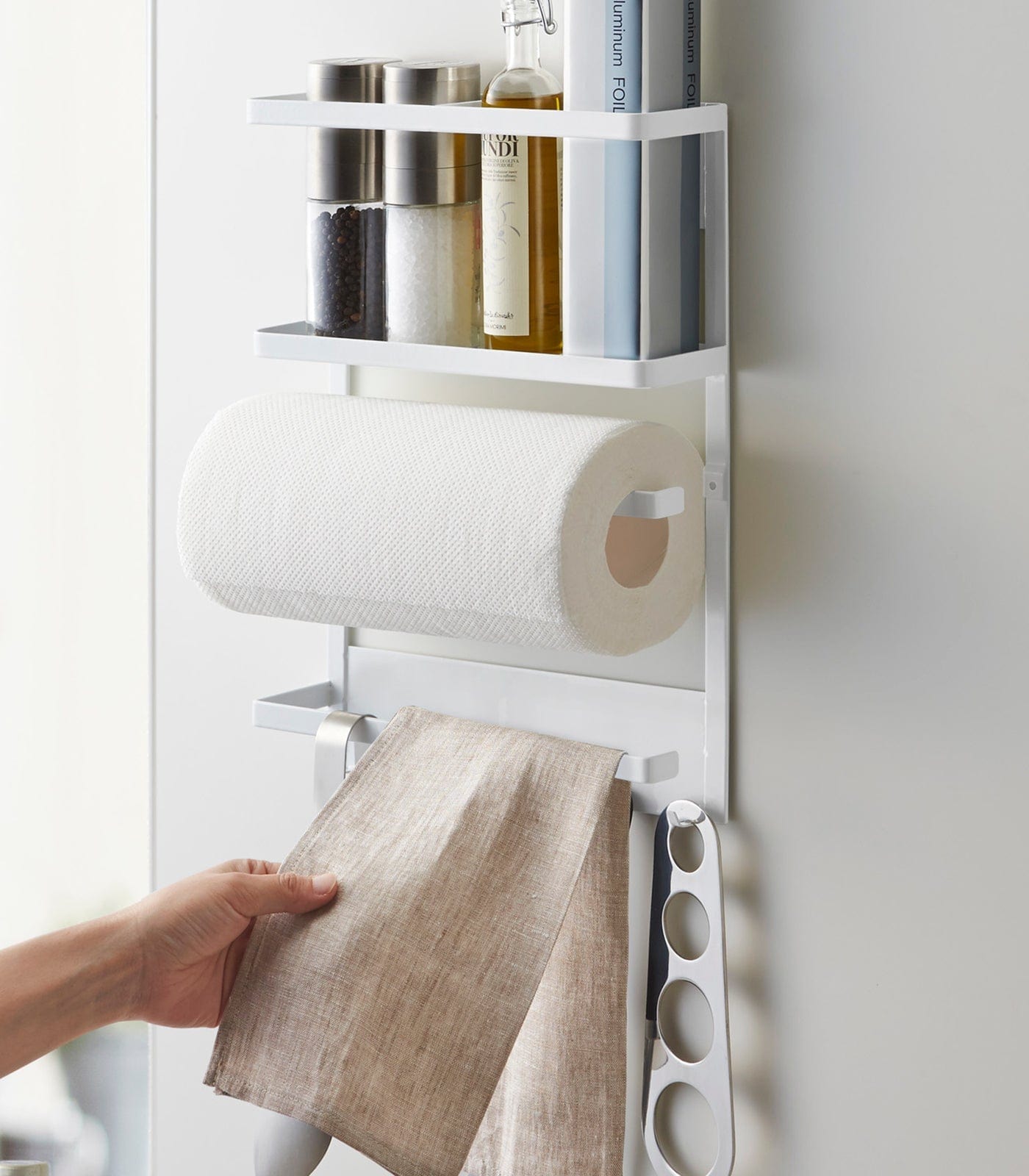 Wall-mounted kitchen organizer with paper towels, bottles, and a towel holder.