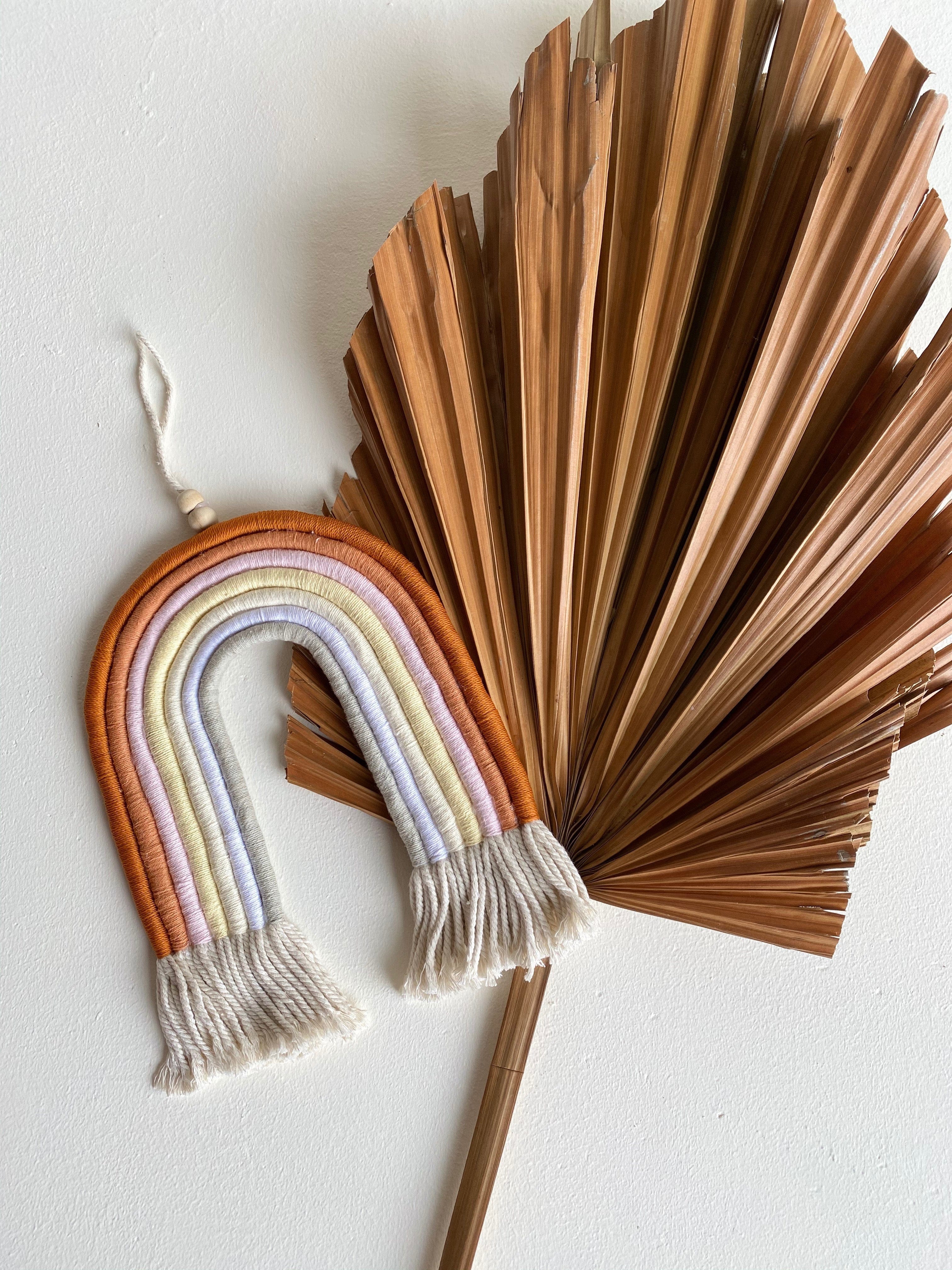 Mia Macrame Rainbow in room on wall with leaf
