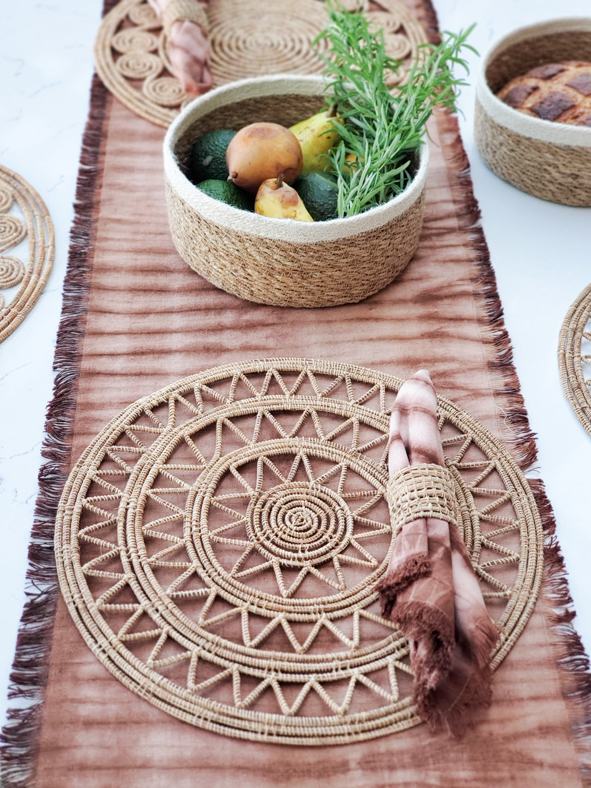 Korissa Woven Palm Fiber Napkin Ring styled with woven placemat on rust dip-dye table runner