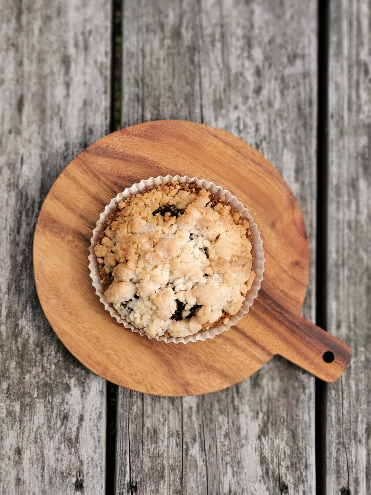 Korissa Wooden Round Serving Board with tart, on weathered wood table