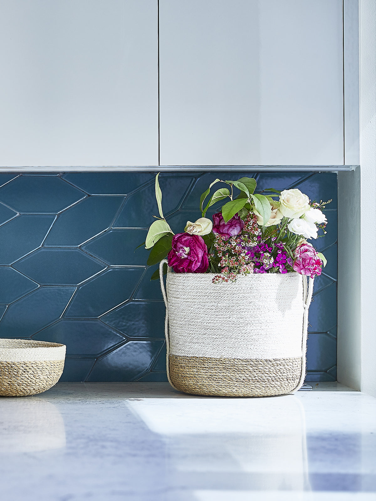 Korissa Savar Basket with Side Handle styled with flowers near window