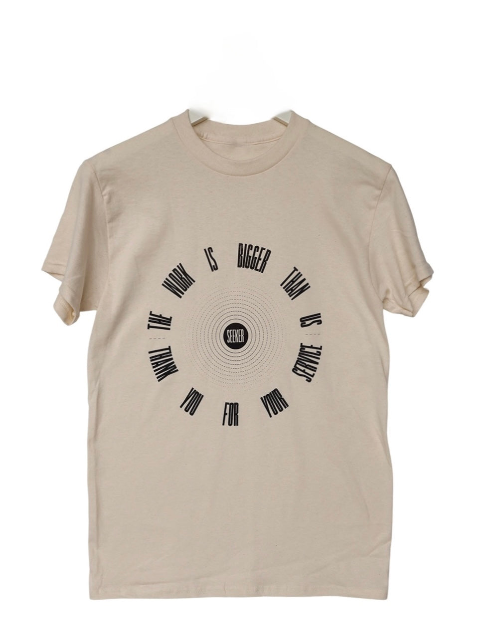 Front product view of the beige Service Tee with a circular arrangement of black symbols around a central emblem.