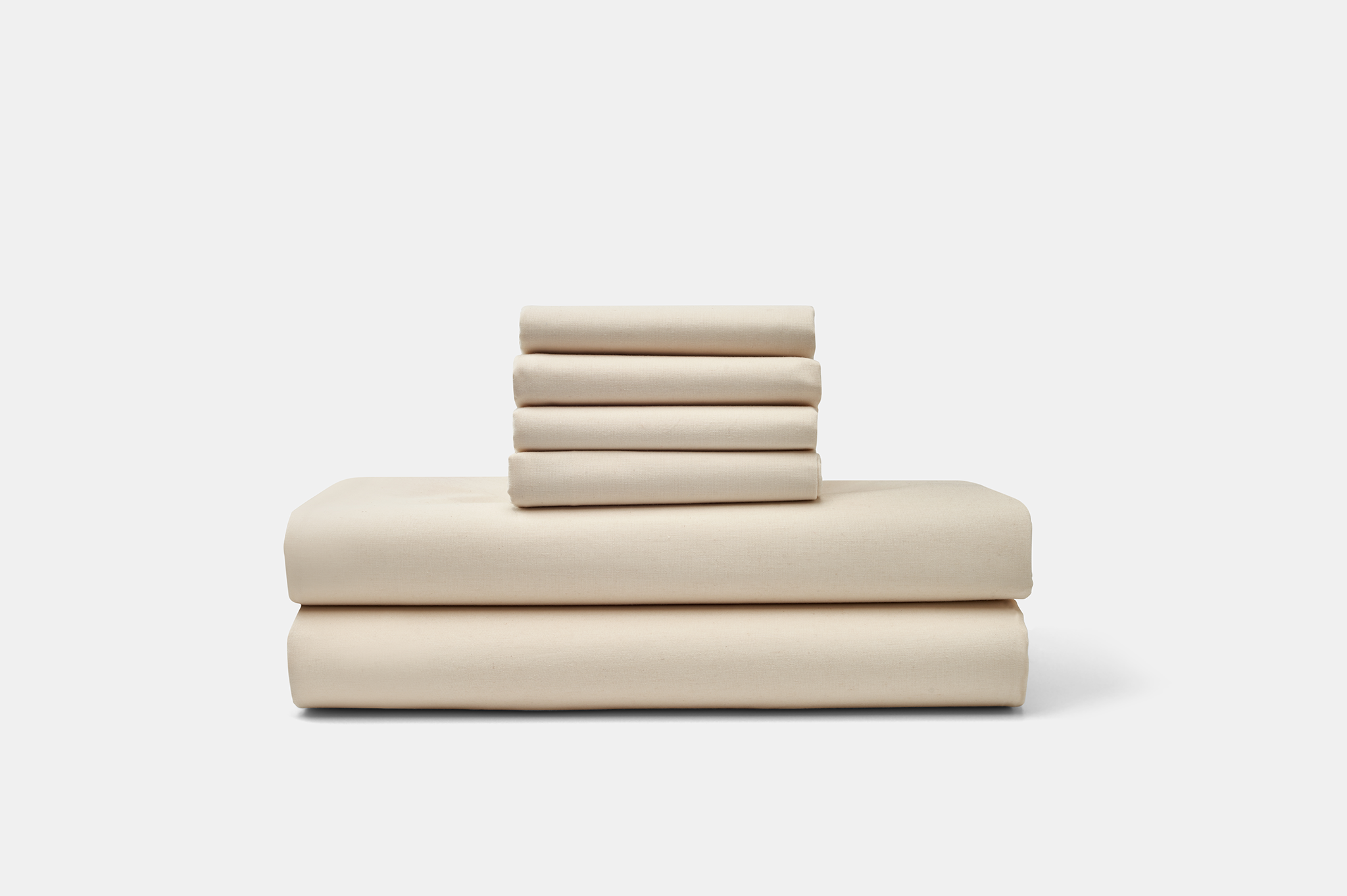 Stacked American Blossom Linens cotton percale sheet set in a natural neutral color