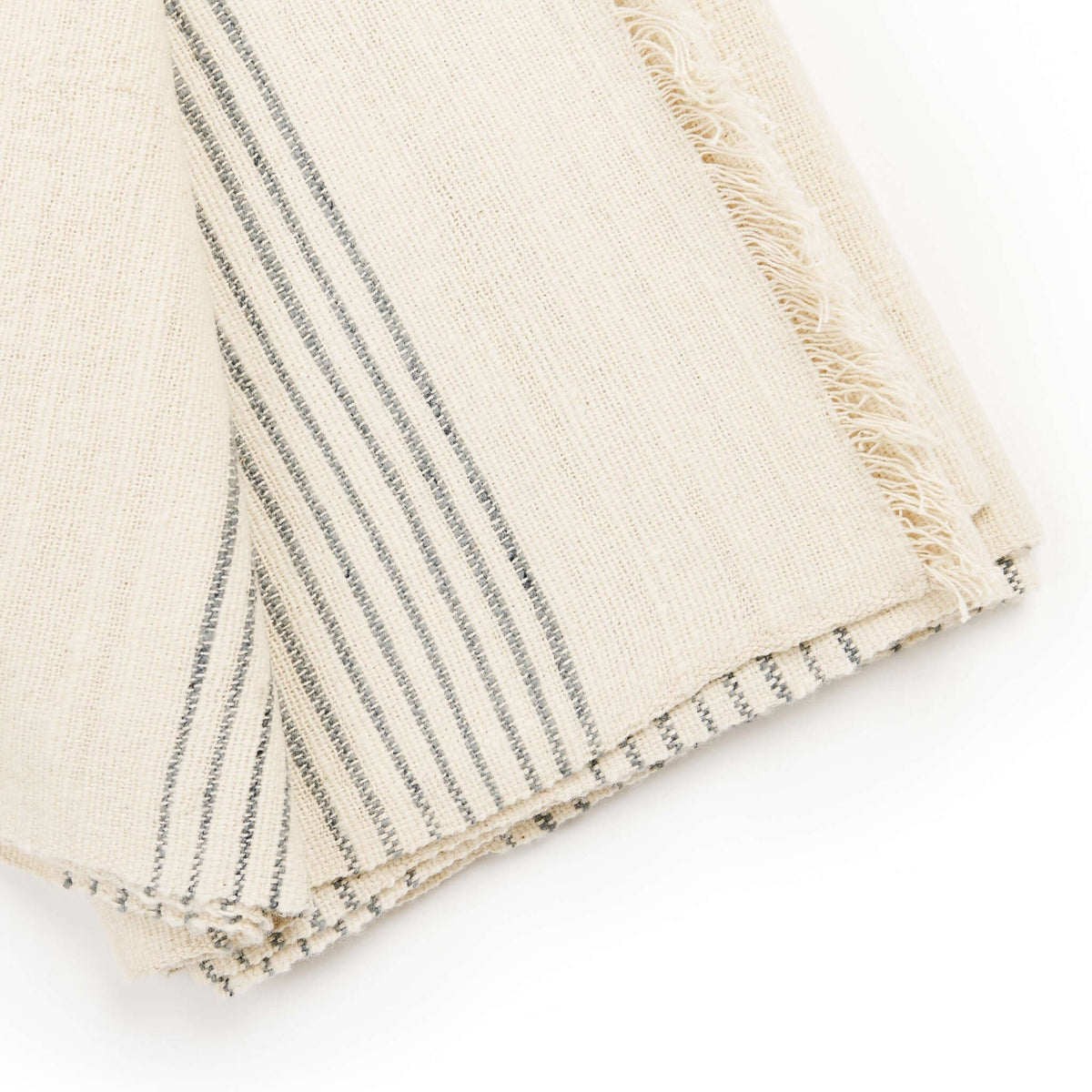 Close-up of a folded Silica Chalk throw corner with grouped charcoal-gray stripes and hand-finished edges