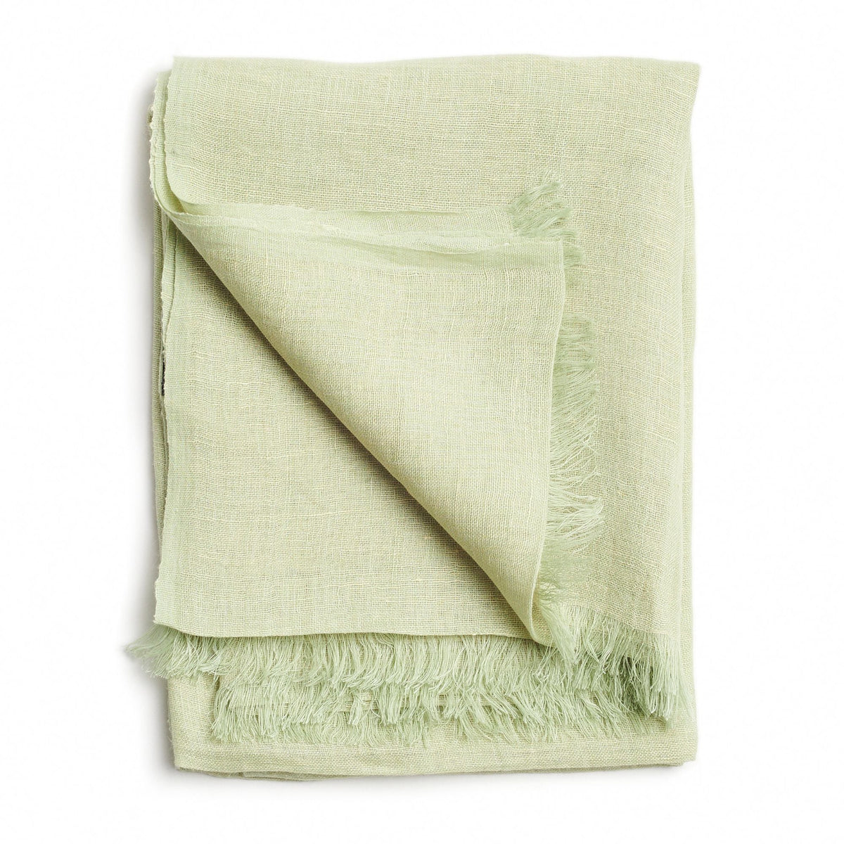 Folded pale green color variation of the Variously handwoven linen-silk scarf with a soft fringed edge