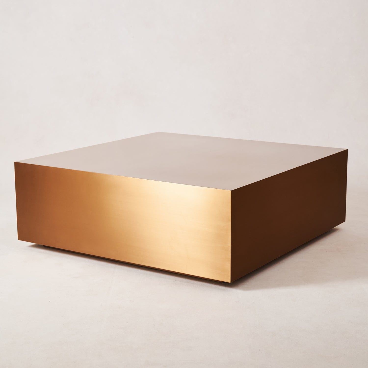 Angled view of copper coffee table showing sculptural geometry