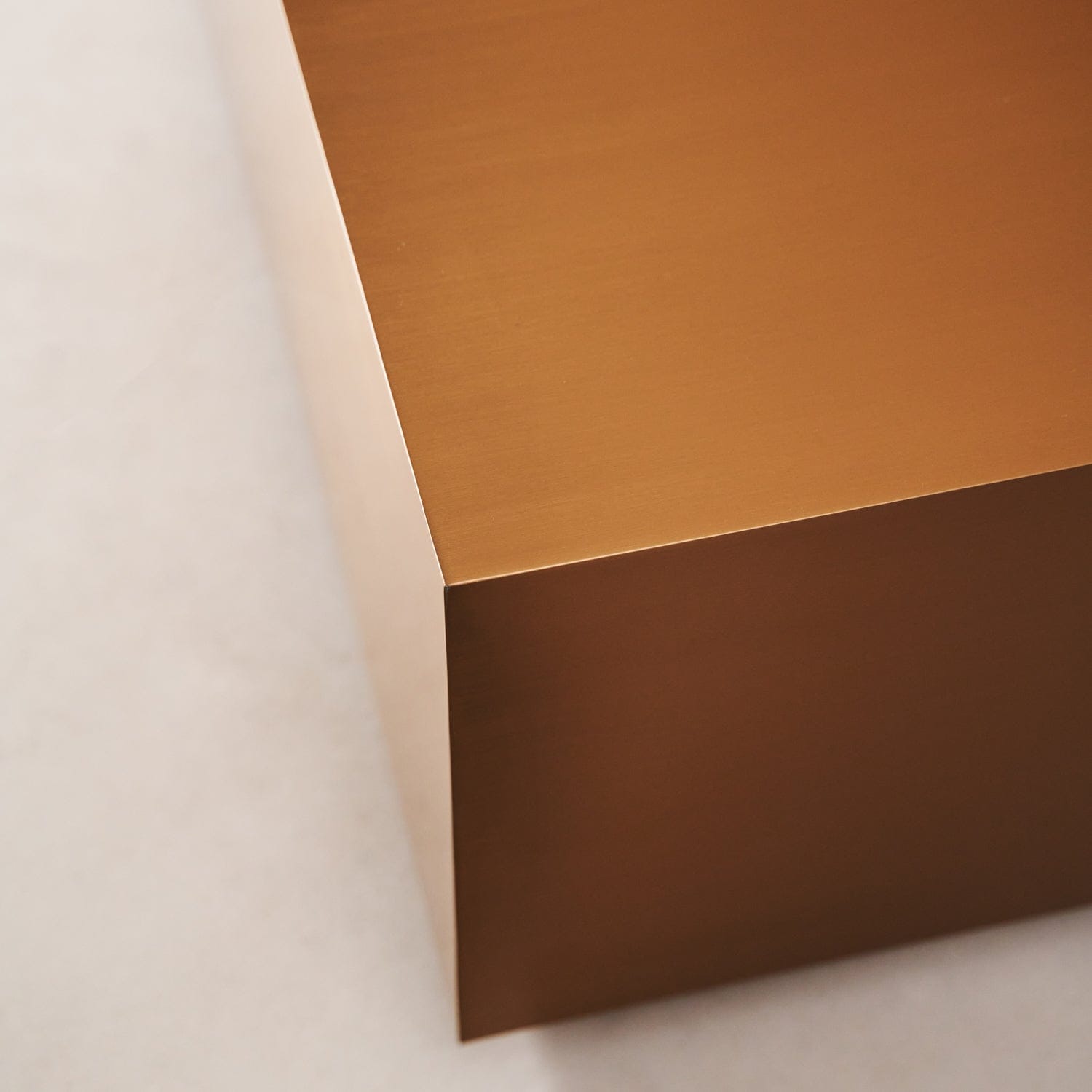 Corner detail of copper coffee table with brushed copper surface