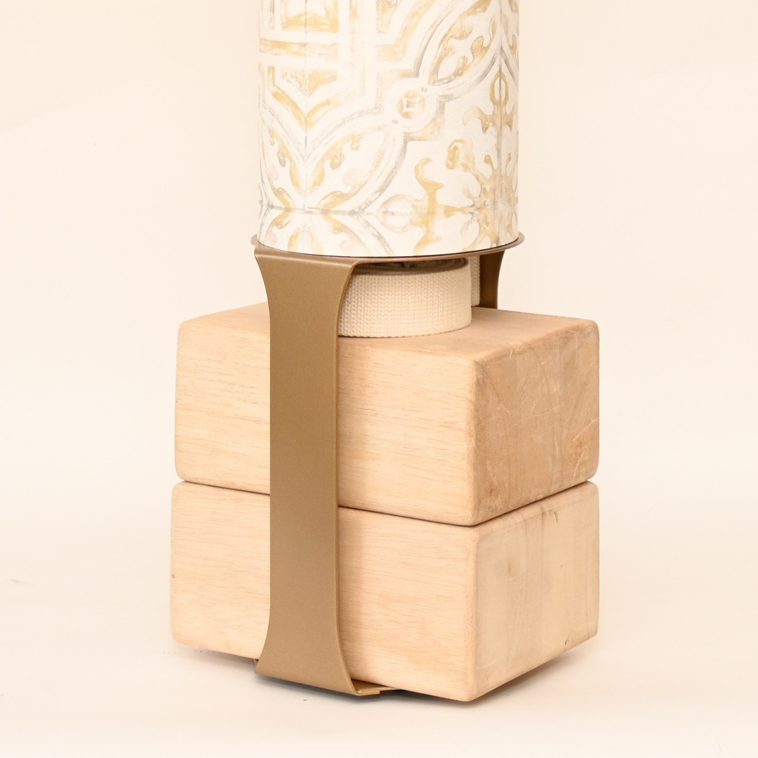 Close-up of the wooden block base secured to the tube with a wide tan strap.