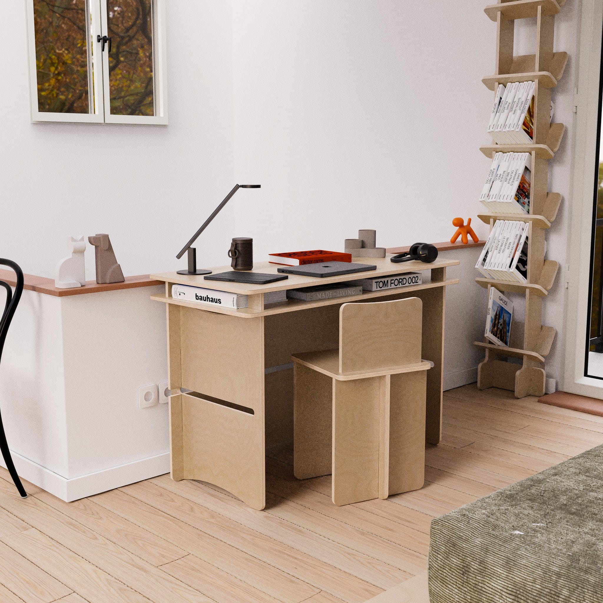 Williamsburg natural wood chair tucked beneath a matching compact desk in a bright home workspace with books, artwork and a floor lamp