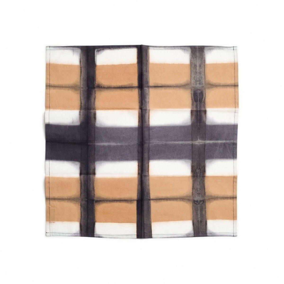 Single Chowk Black table napkin laid flat to display its bold hand-dyed black grid over tan and white blocks