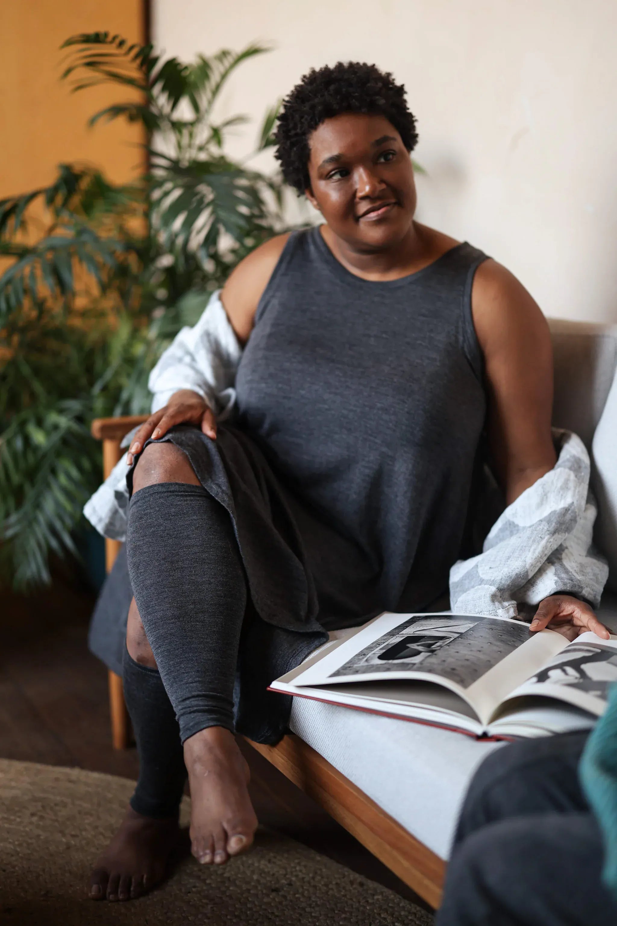 Merino wool leg warmers worn while relaxing indoors, providing lightweight warmth and breathable natural comfort.