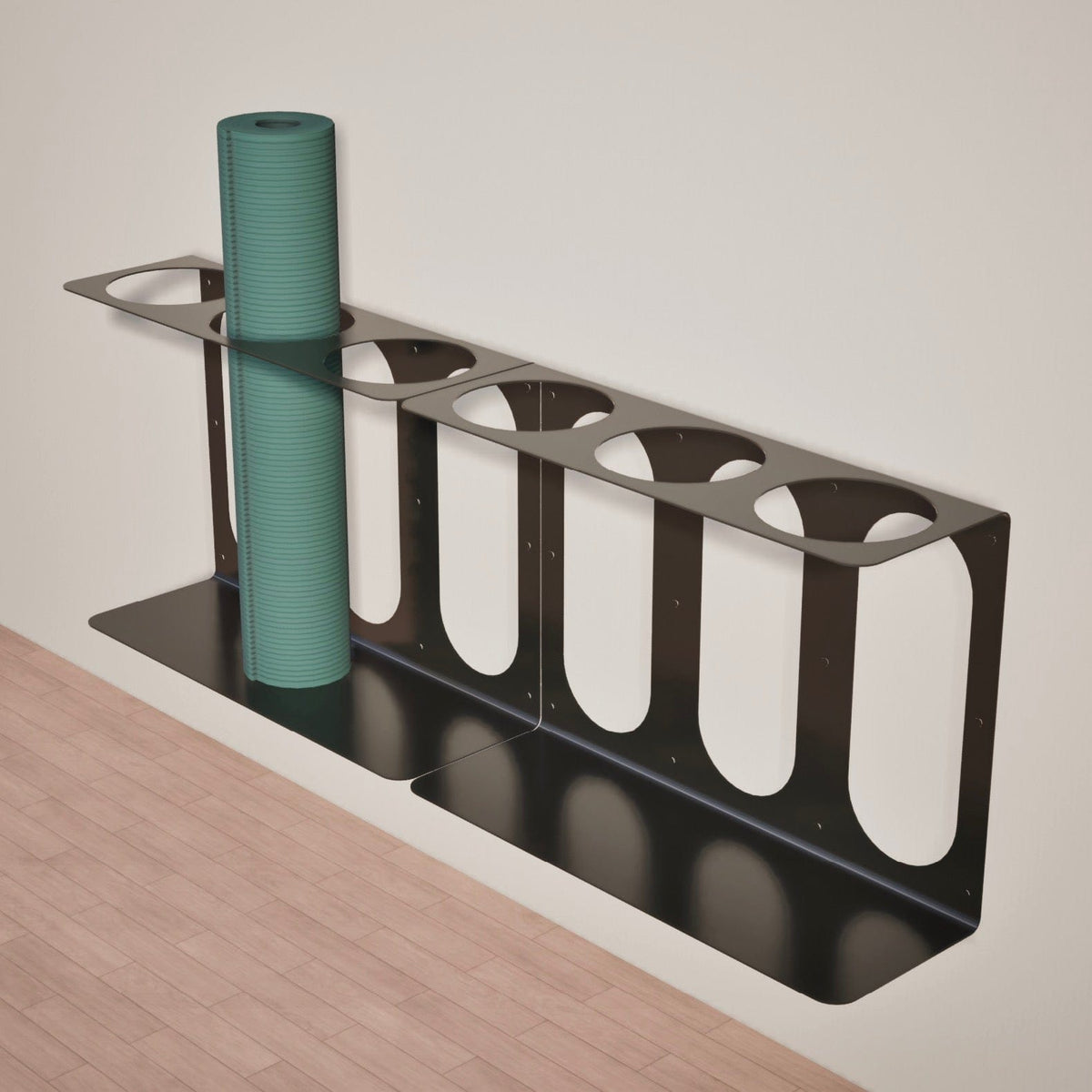Angled view of the black three-slot bracket holding a tall teal foam roller against a light wall.