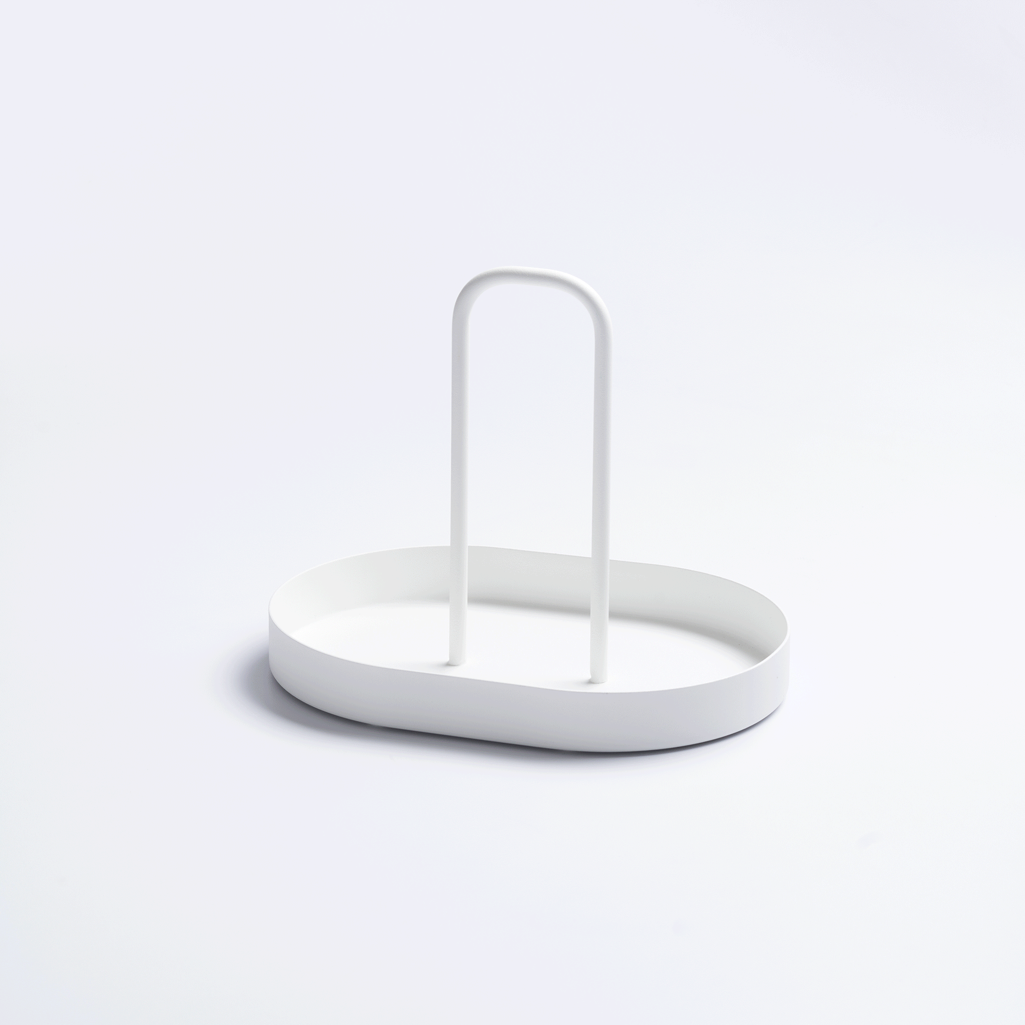 White Yamazaki Home Vanity Tray with Handle - Steel filled with upright green, cream and orange packets arranged around its central handle on a pale background.