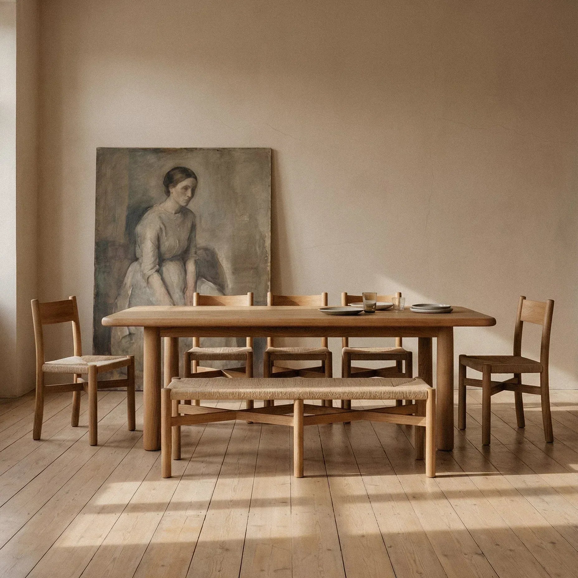 Minimalist dining space with woven jute dining chairs in warm oak