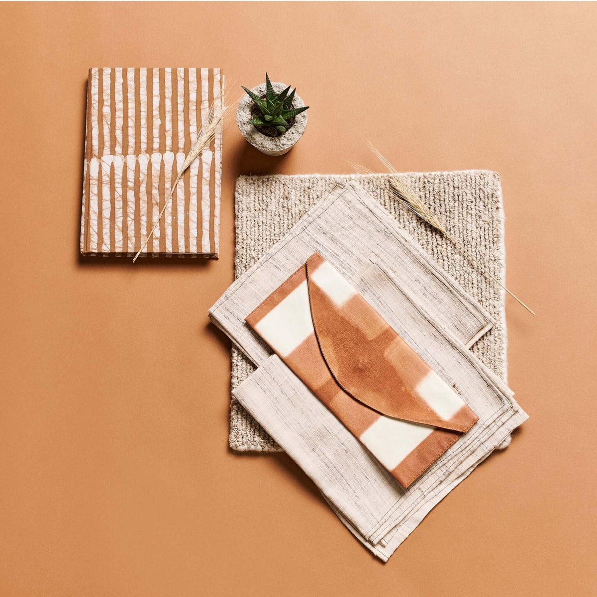 Oak Brown journal styled on a terracotta surface with another handmade journal, art prints and a small succulent