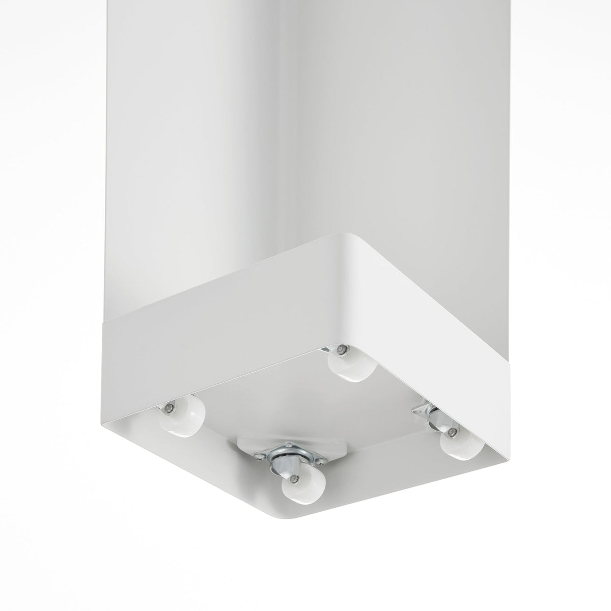 Underside view of the white Yamazaki Home Rolling Bathroom Organizer - Steel, showing small caster wheels beneath its square base.