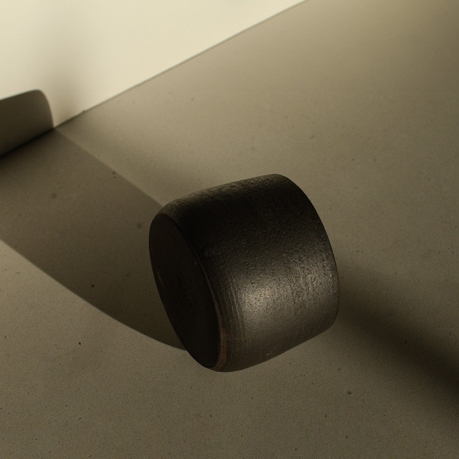 Black cylindrical object on a beige surface