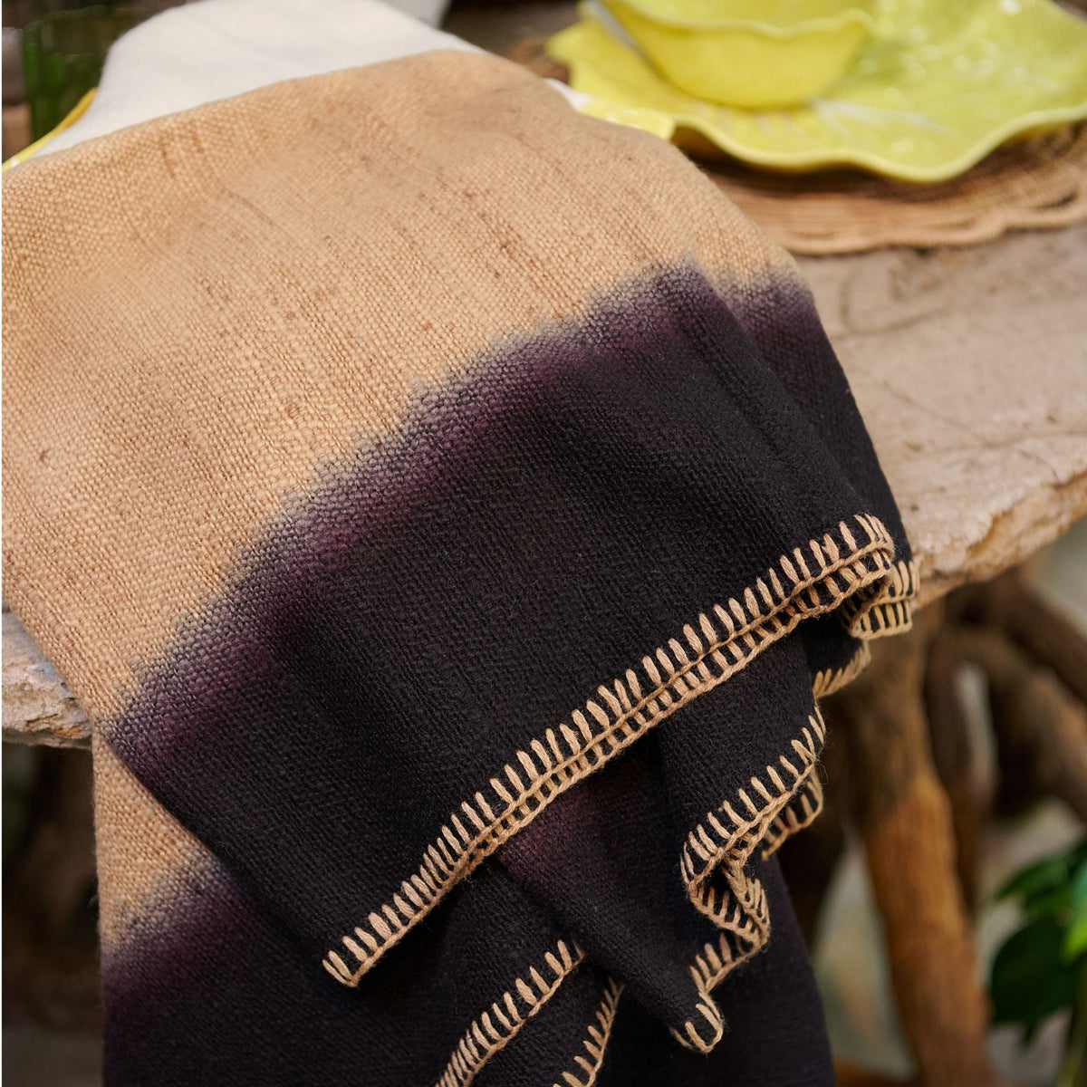 Close-up of the folded Siro Brown throw showing the transition from tan to black and the contrasting blanket stitching