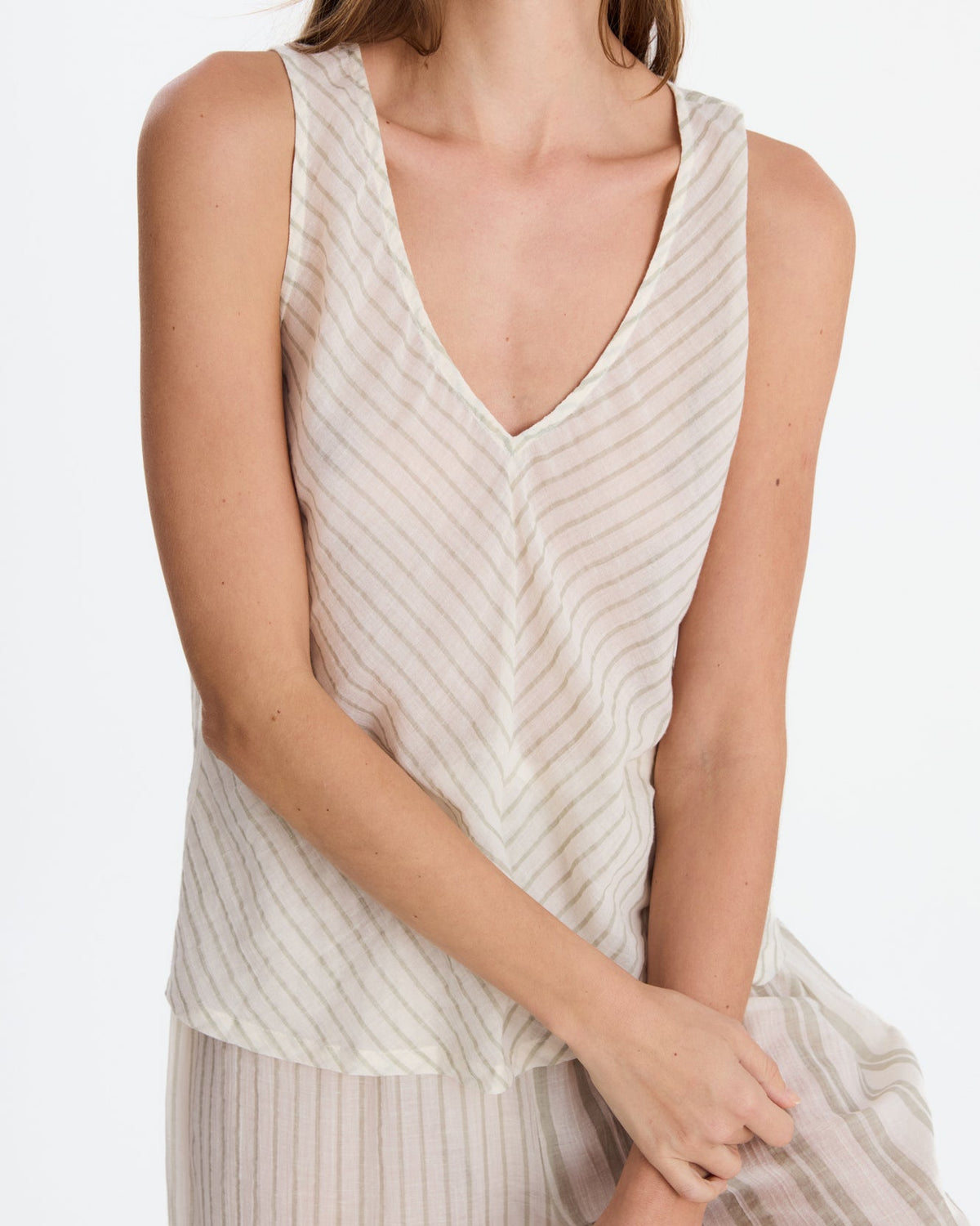 Close-up of the top’s V-neckline and diagonal stripes meeting at the center seam, with part of the vertically striped pants visible below.