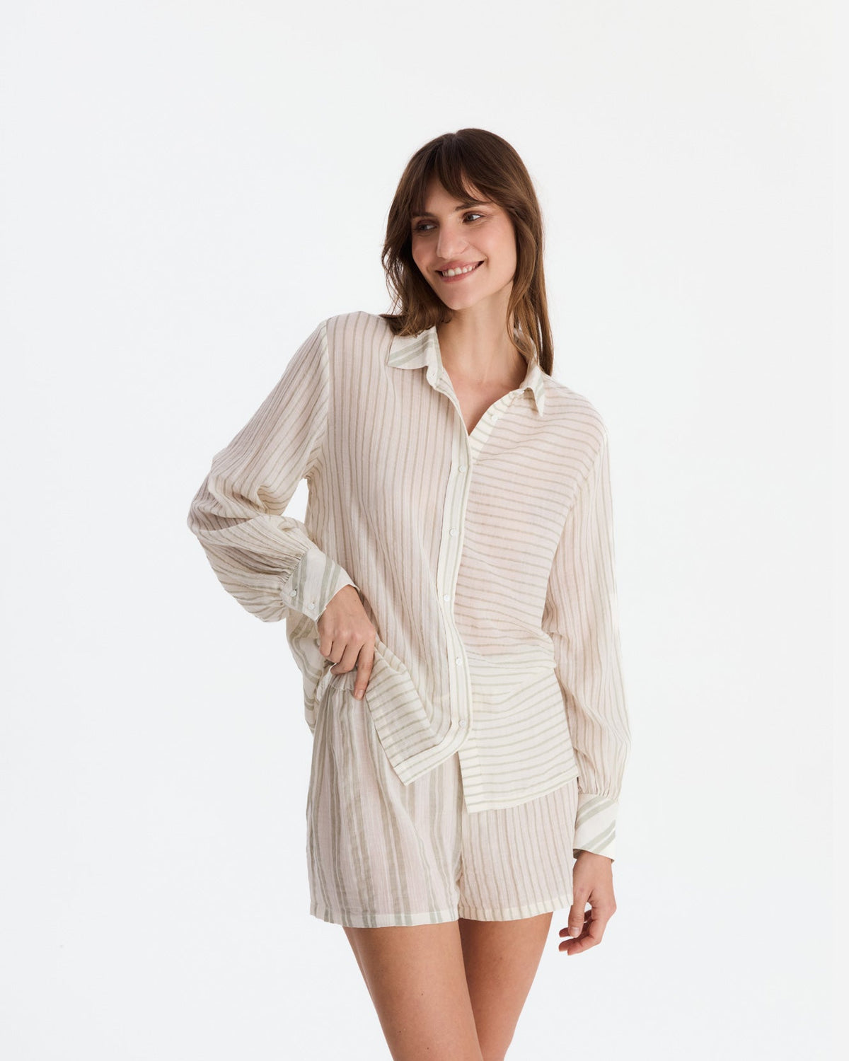 Closer front view with one hand at the waist, showing the shirt’s horizontal and vertical stripe panels above matching shorts.
