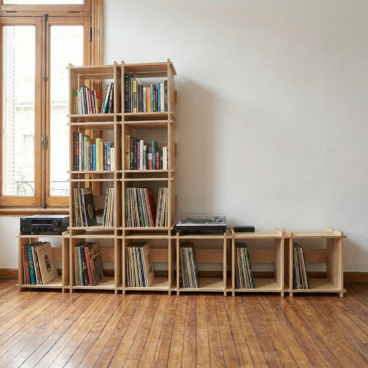 Wall of Williamsburg Cubical modules configured as tall and low shelving, filled with books, vinyl records and a turntable