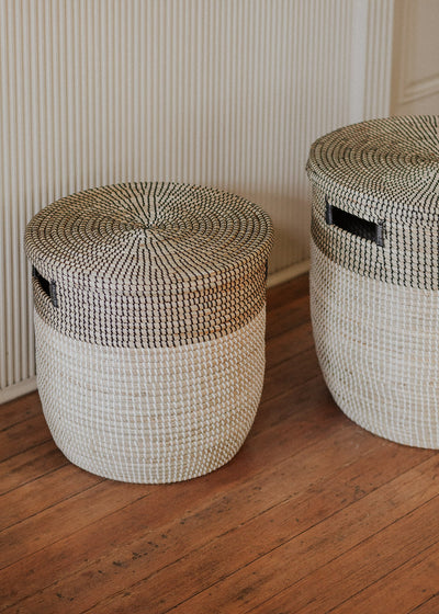 Close lifestyle view of two Black Medina basket sizes on a warm wood floor.