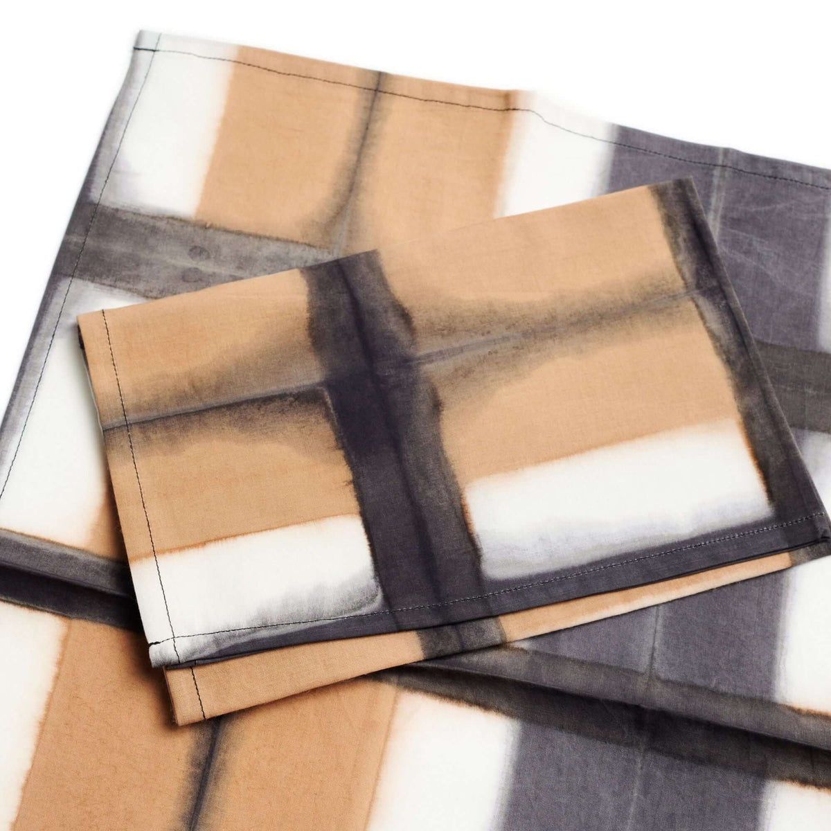 Chowk Black cotton napkins arranged in an overlapping stack, highlighting variations in the handcrafted grid pattern
