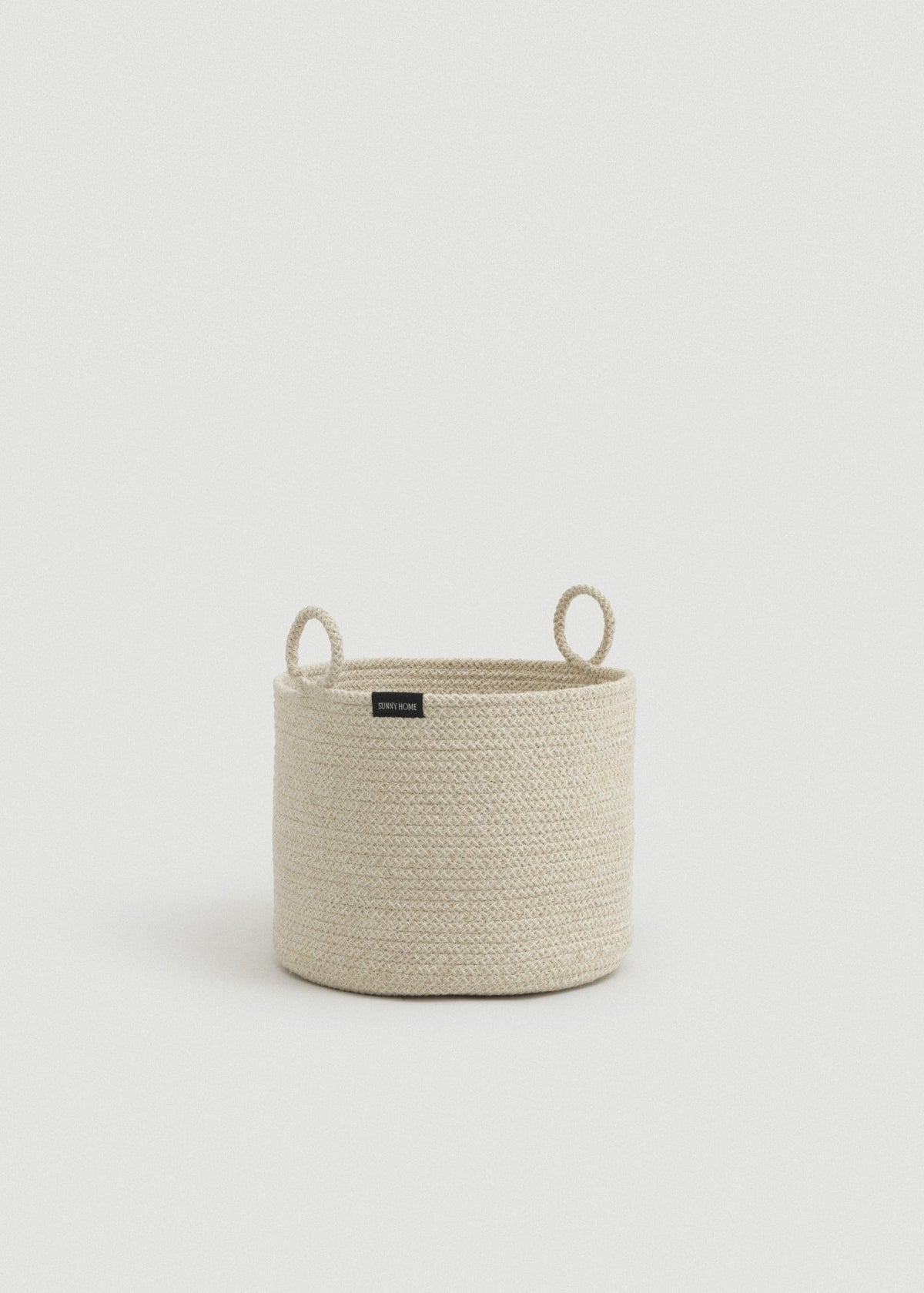 Beige melange cotton rope storage basket with a cylindrical shape and two upright loop handles.