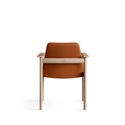 Rear view of the cognac-orange Eikund Ry Arm Chair, showing the smooth curved back panel, horizontal light wood rail, and slender rear legs against white.