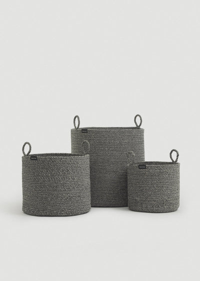 Three gray cotton rope baskets in graduated sizes arranged together.
