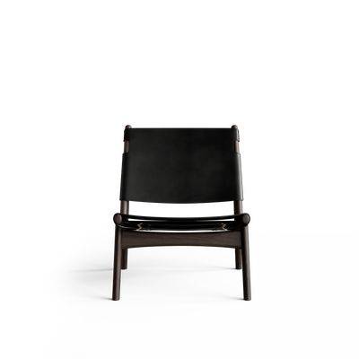 Front view of the Eikund Hunter Lounge Chair with black leather panels, showing the broad rectangular backrest, low suspended seat, curved front rail, and dark wood legs.