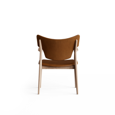 Rear view of the cognac-brown Eikund Veng Arm Chair, showing the curved upholstered back between light wood uprights and an open gap above the seat.