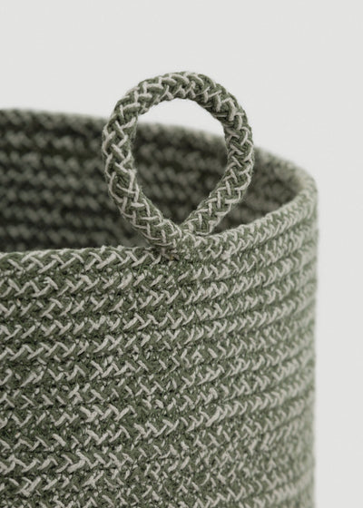 Close-up of the green-and-cream braided rope, rounded rim, and circular loop handle.