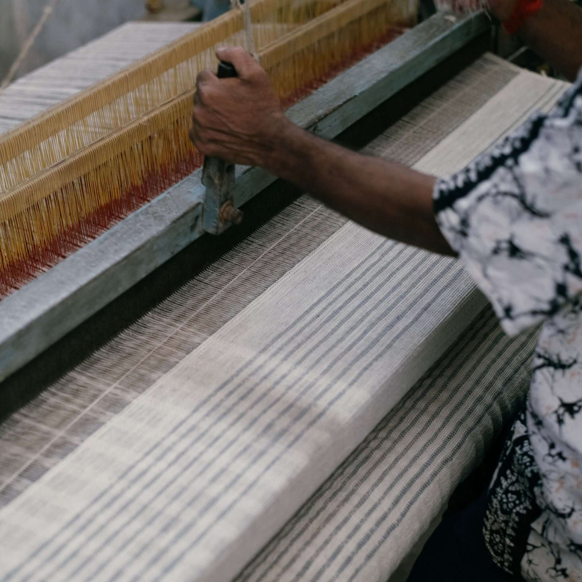 Artisan weaving the Silica Chalk striped throw by hand on a traditional loom