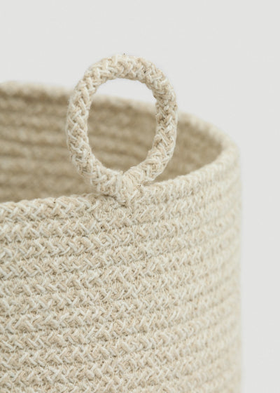 Close-up of the cream-and-beige braided rope, rounded rim, and circular loop handle.