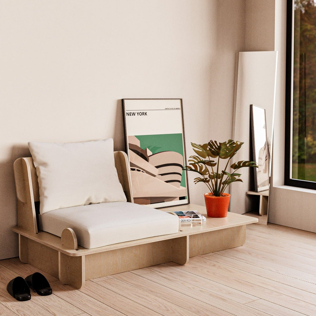 Franklin single low seater with an extended side platform holding books and a small plant beside framed artwork