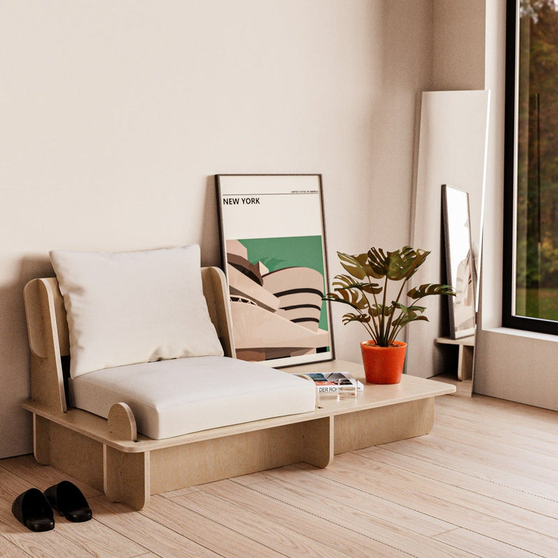 Franklin single low seater with an extended side platform holding books and a small plant beside framed artwork